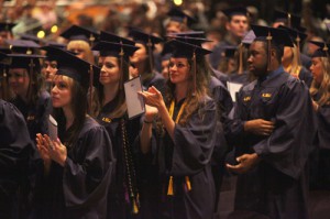 身着紫袍的学生在毕业典礼上鼓掌