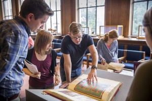 人们聚集在图书馆的手稿周围